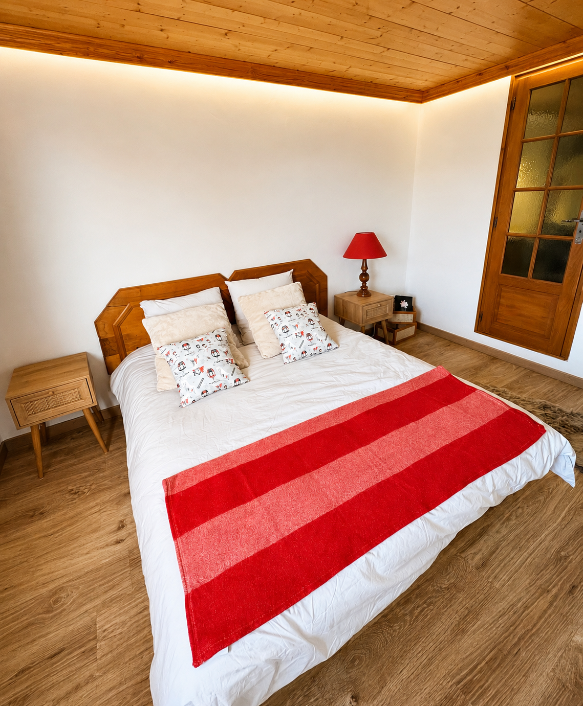Chambre avec plaid en fourrure et grande fenêtre sur la montagne