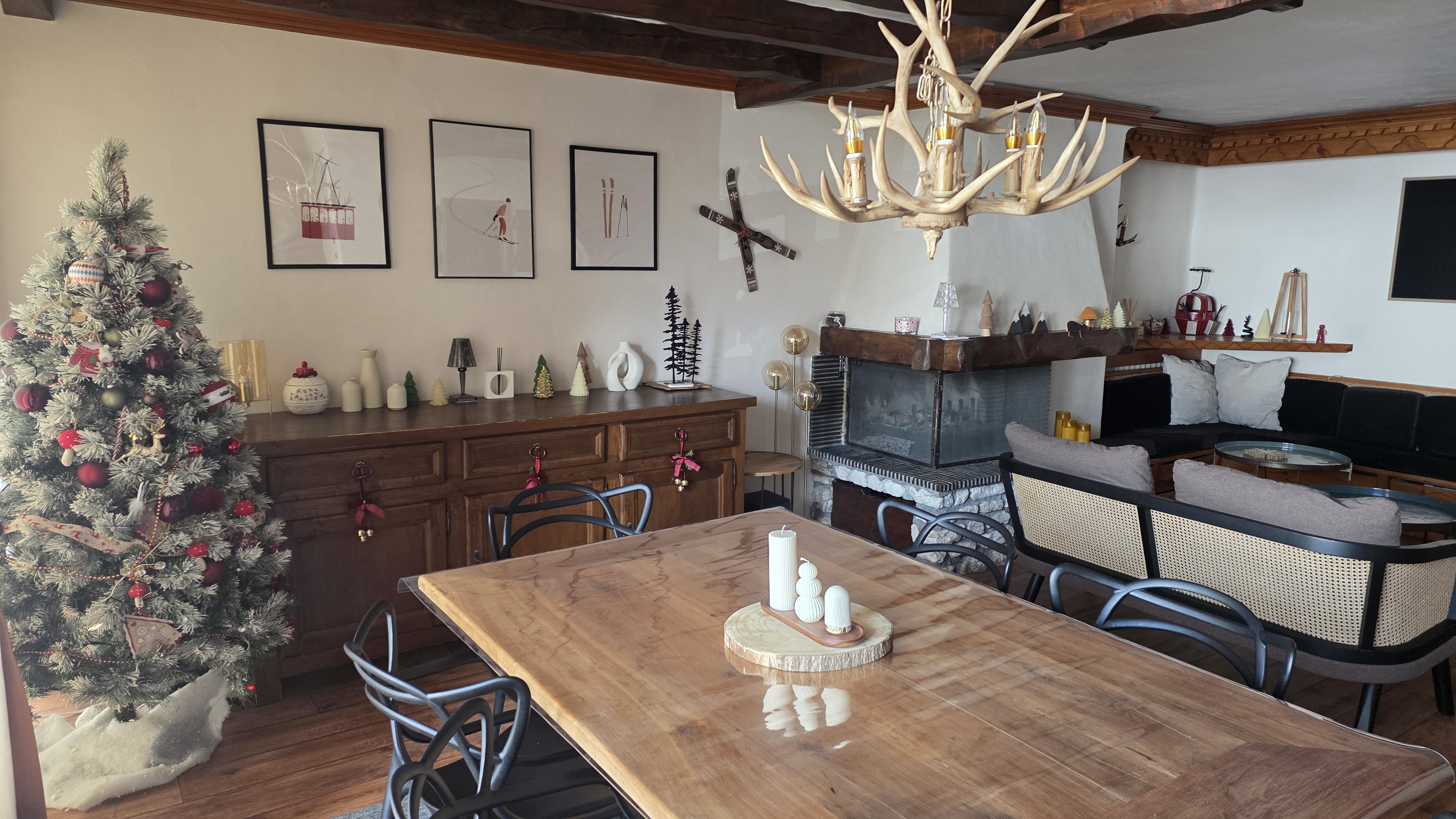 Séjour chaleureux avec cheminée, table en bois massif et lustre bois de cerf
