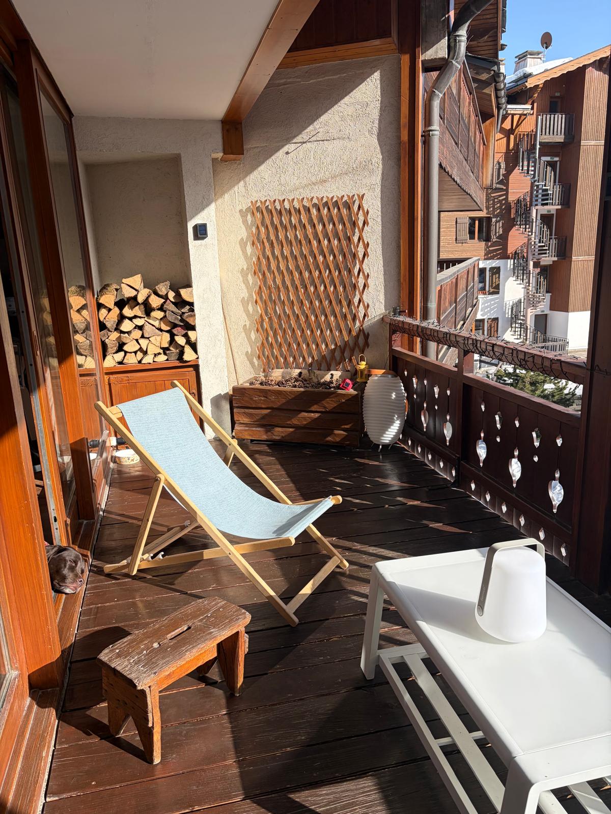 Terrasse ensoleillée avec transats et réserve de bois